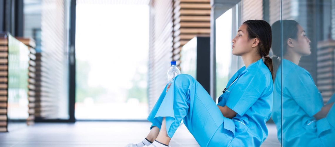 depressed-nurse-sitting-on-floor-WT8Z26Q_WEB